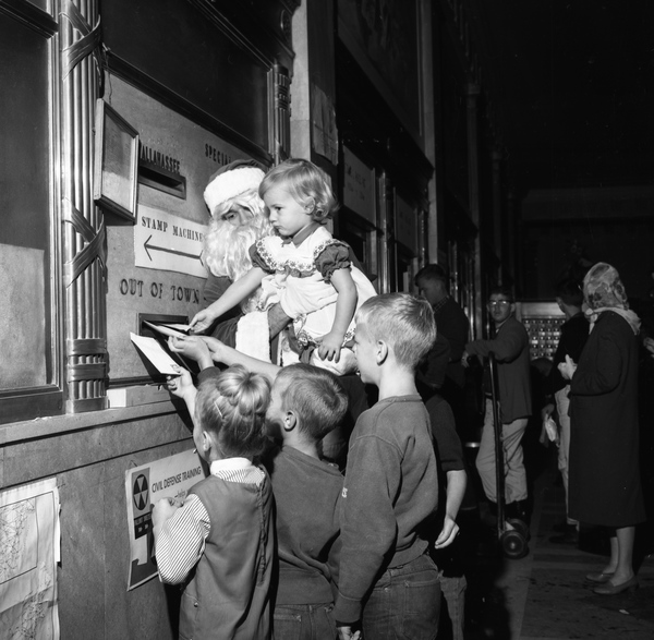 Children with Santa mailing letters to Santa from Tallahassee. Charlotte Pullen, top right, held by Santa.