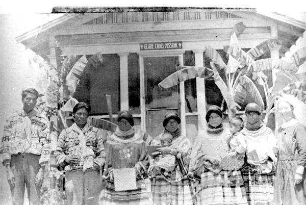 Miccosukee men and women with their crafts outside the mission