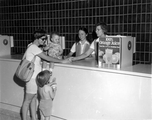 Tourists receive orange juice at the Welcome Station (1977).