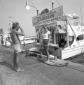 A man taking a picture for a young woman in front of a charter boat - Destin, Florida