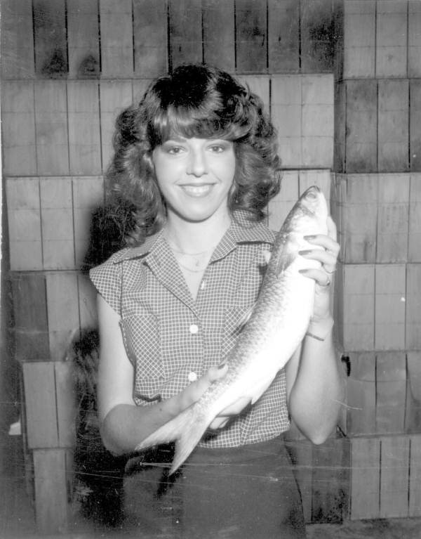 Woman holding up a large black mullet at the Boggy Bayou Mullet Festival (1978).