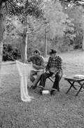 Apprentice Reginald Reis works on a cast net while master netmaker Max Dooley looks on - Lakeland, Florida.