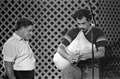 Greek bagpiper Nikitas Tsimouris of Tarpon Springs looks on as apprentice George Pilatos performs at the 1985 Florida Folk Festival - White Springs, Florida