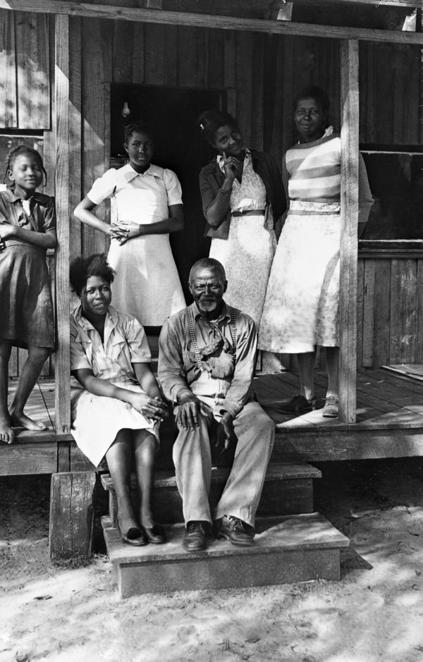 Employees of the Lewis Plantation on the porch of a home on the grounds (circa 1940s).