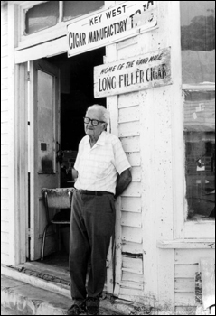 Rex Shaw standing in front of his factory on Fleming Street: Key West, Florida (197-)