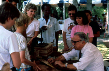 People watching Raphael Ozambela roll cigars at the 1986 Florida Folk Festival: White Springs, Florida (1986)