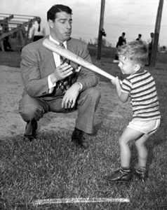 Joe DiMaggio showing three year old Larry Valencourt how to hold a bat: West Palm Beach, Florida (1948)