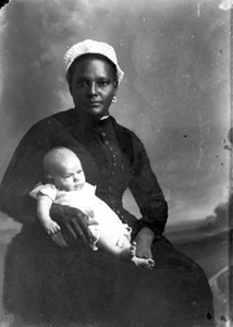 White-capped nurse holding an infant