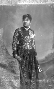 Woman in lace-overlay dress, holding a fan