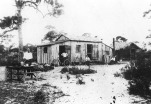 Japanese American men sitting by a home: Yamato, Florida (19--)