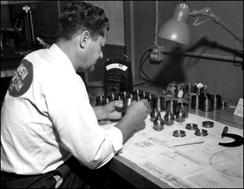 A worker inspecting finished beryllium parts at the Visioneering Company: Sarasota, Florida (1959)