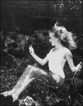 Mermaid at Weeki Wachee Springs viewing herself in a mirror (1969)