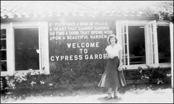 Unidentified lady stands in front of the sign for Cypress Gardens: Winter Haven, Florida (19--)