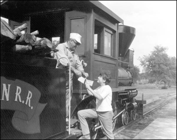 Young visitor gets autograph from train engineer at Pioneer City: Davie, Florida (1967)