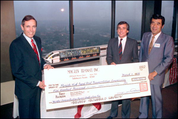 Akio Makiyama, Chairman of Maglev Transit, Inc (right) presents a check to Governor Bob Martinez (left) and Chairman Malcolm Kirschenbaum (center right): Tallahassee, Florida (1988)