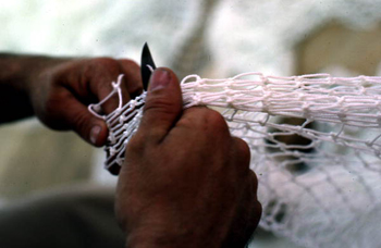 Net maker at work repairing a fishing net: Fernandina Beach, Florida (not after 1980)