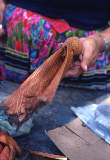 Mary B. Billie displaying work during the process of attaching a Seminole doll head to the body 