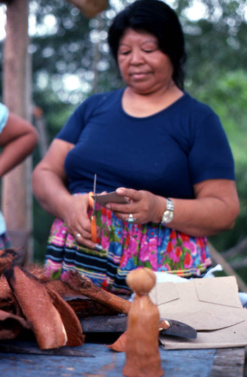 Mary Billie cutting cardboard for the Seminole doll she is making: Big Cypress Seminole Indian Reservation, Florida 