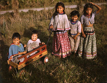 Seminole children with a toy wagon at the Brighton Indian Reservation (ca. 1948)