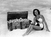 Margie Fletcher in a beach scene, posing with an orange-filled treasure chest - Winter Haven, Florida