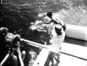 A fisherman looks another man trying to gaff a fish during the Shakespeare fishing trip - Panama City, Florida.