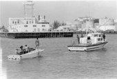 U.S. Customs boat towing vessel with Cuban refugees on board during the Mariel Boatlift - Key West, Florida.