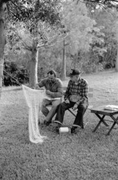 Apprentice Reginald Reis works on a cast net while master netmaker Max Dooley looks on - Lakeland, Florida.