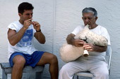 Greek bagpipe player Nikitas Tsimouris, right, plays the tsabouna, accompanied by his apprentice and grand-nephew Nikitas Kavouklis on the practice chanter - Tarpon Springs, Florida