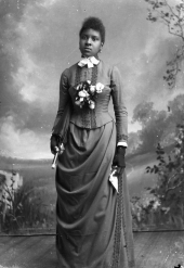 Woman holding a parasol and handkerchief.