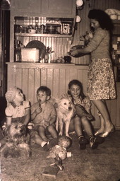 Mother with kids and dogs in the kitchen.