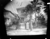 Mary "Mae" Martin standing outside the gate to her home