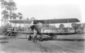 Man posing in front of a biplane, part of Mabel Cody's Flying Circus - Coral Gables, Florida.