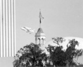 Space shuttle Discovery flying over Florida's capitol building.