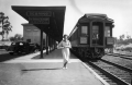 A young woman stands near "the Orange Blossom Special" train at railroad depot - Sebring, Florida.